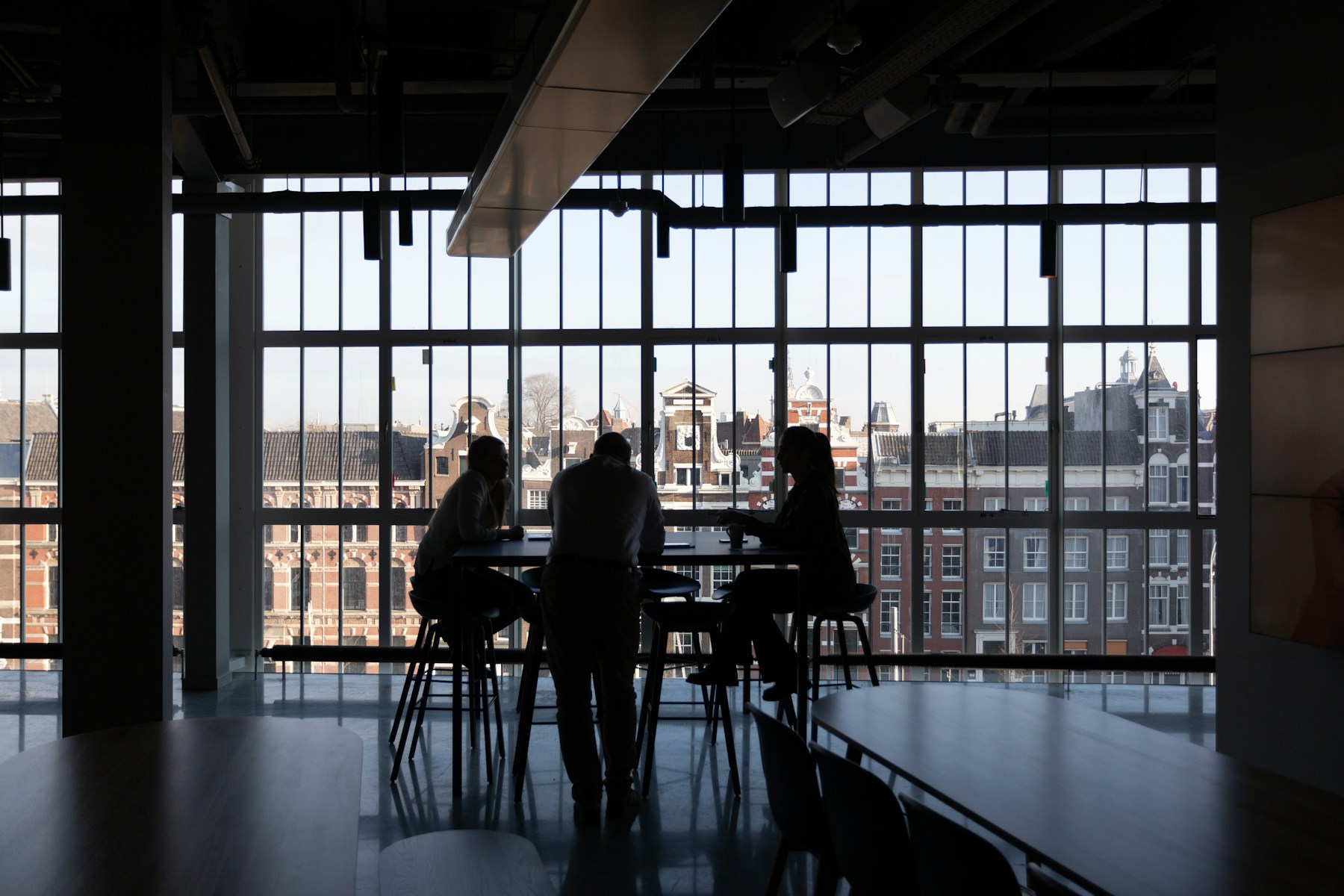 A small team at a table against a city window