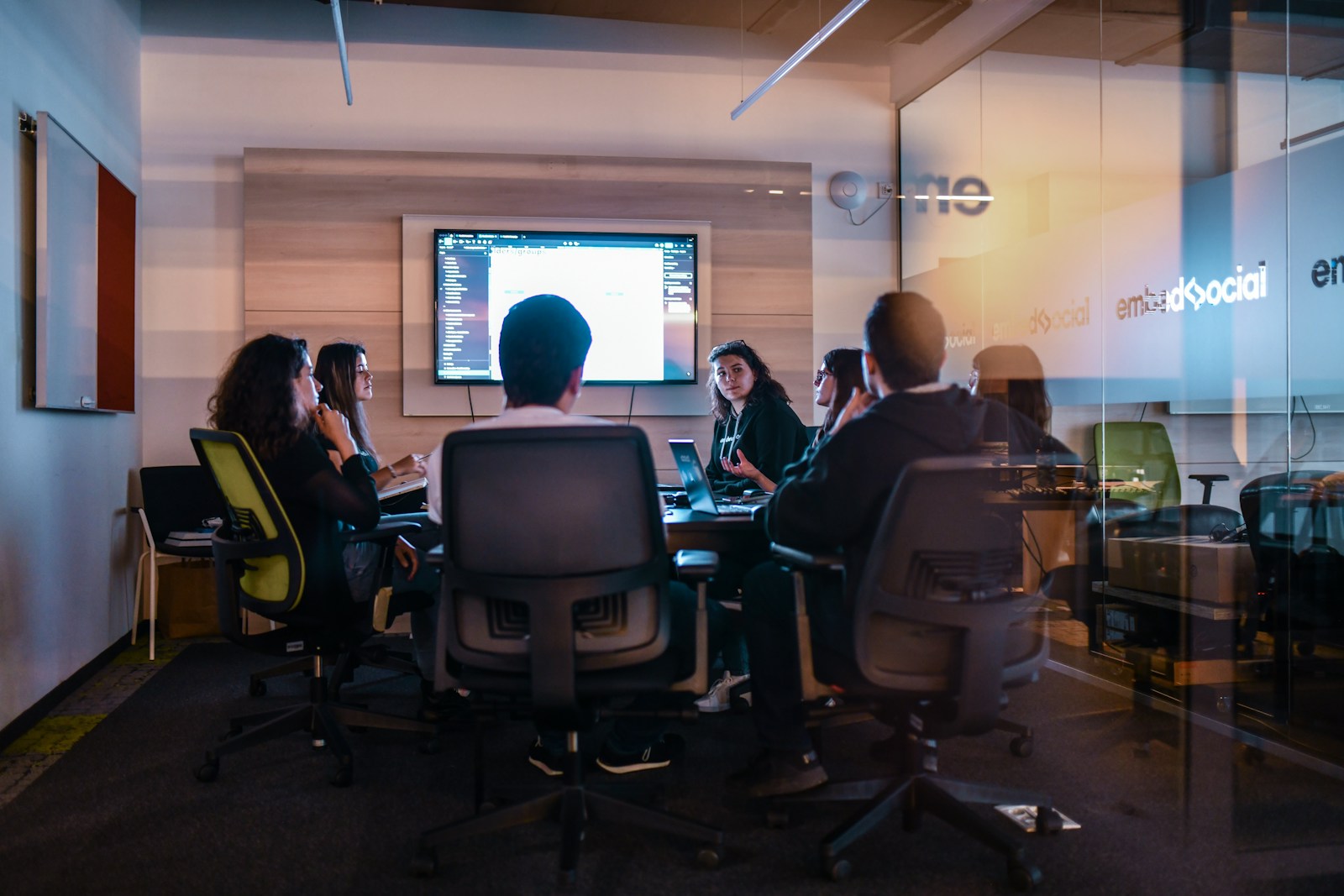 A team watching a demo on the room's screen