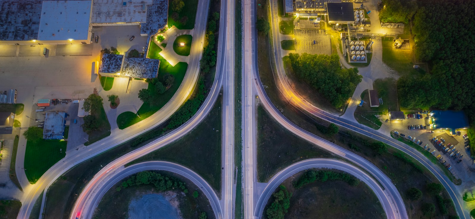A highway interchange from above at dusk, roads converging and splitting
