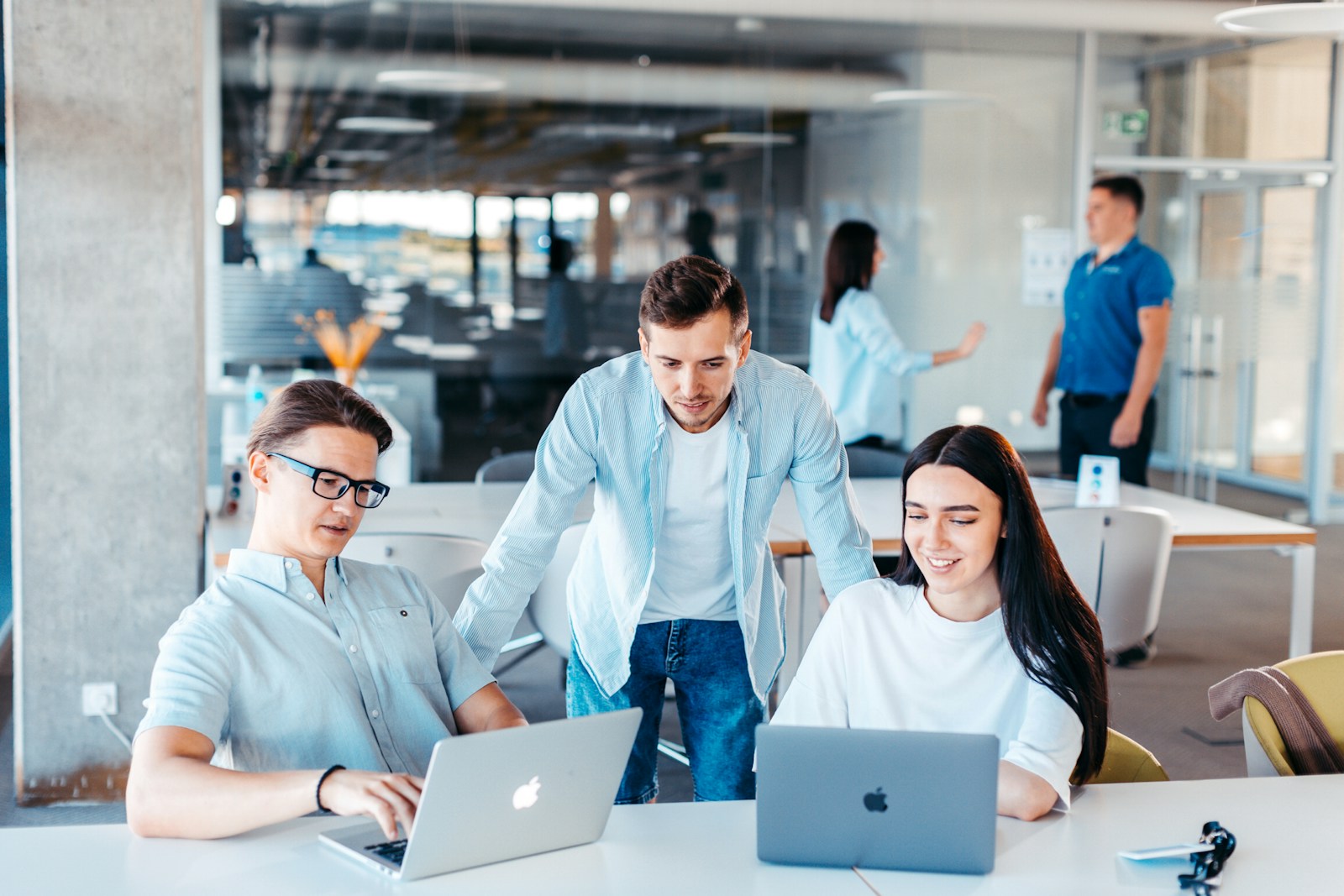 A team building together at laptops in an open office